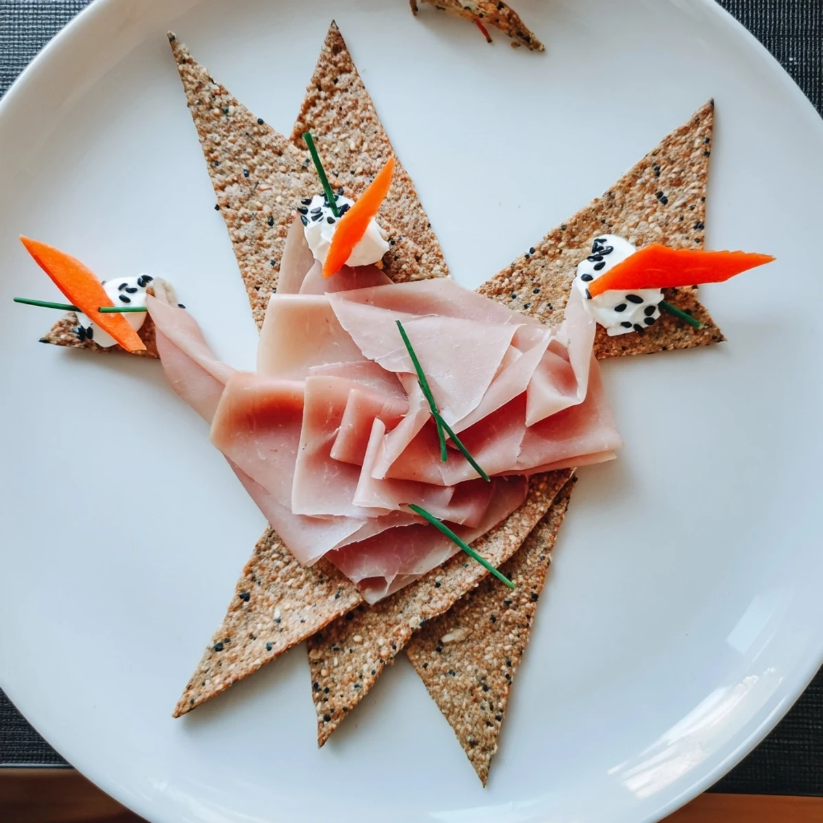 Delectable Paper Crane appetizer of folded meats, crackers, and carrot garnishes ready for serving.