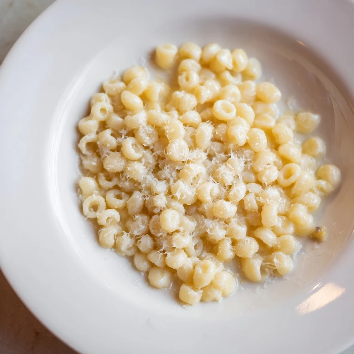 Close-up of golden 15-Minute Garlic Parmesan Pasta, perfectly coated in sauce and ready to serve with extra cheese.