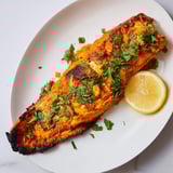 Vibrant red Indian Tikka Salmon glistens, perfectly roasted and infused with aromatic spices for dinner.