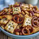Tangy sourdough Cheez-Its, crunchy pretzels, and mixed nuts tossed in seasoned butter create an irresistible party snack.  