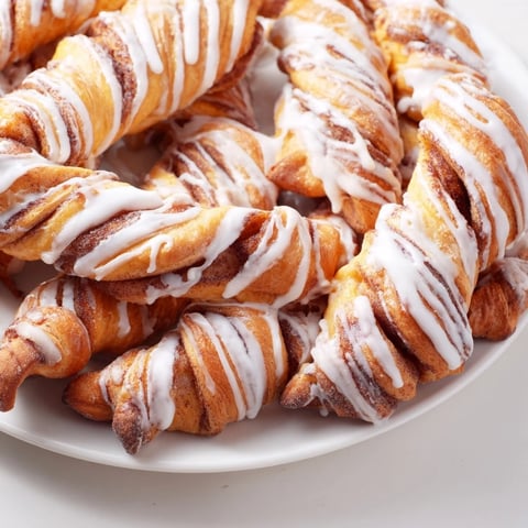 Golden air-fryer cinnamon roll twists, drizzled with sweet glaze, a perfect grab-and-go breakfast.