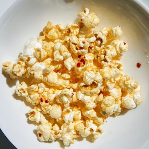 Golden, glistening Hot Honey Butter Popcorn, a sweet and spicy treat for your next movie night.