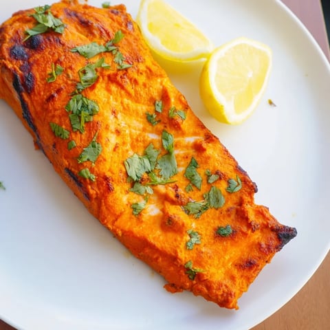 Golden-crusted Indian Tikka Salmon, beautifully marinated and ready to serve with fresh coriander.