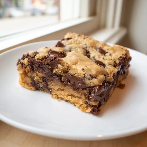 These Ultimate Gooey Chocolate Chip Cookie Bars offer a delightful combination of soft, chewy textures and rich flavors.