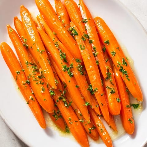 Golden Honey-Glazed Carrots glistening with a sweet, buttery glaze, garnished with fresh parsley.