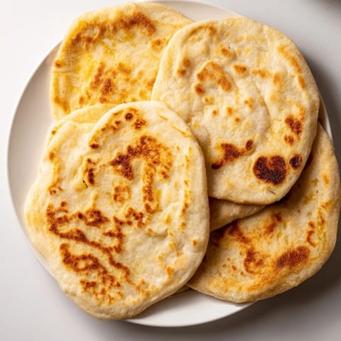 Warm, griddle-cooked Three-Ingredient Easy Flatbreads with slightly puffed, bubbly surfaces, ready to eat.