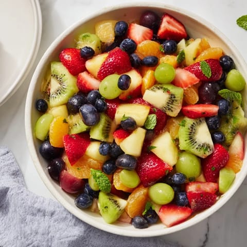 Refreshing fruit salad with honey-lime dressing, a chilled dessert bursting with summer flavors.