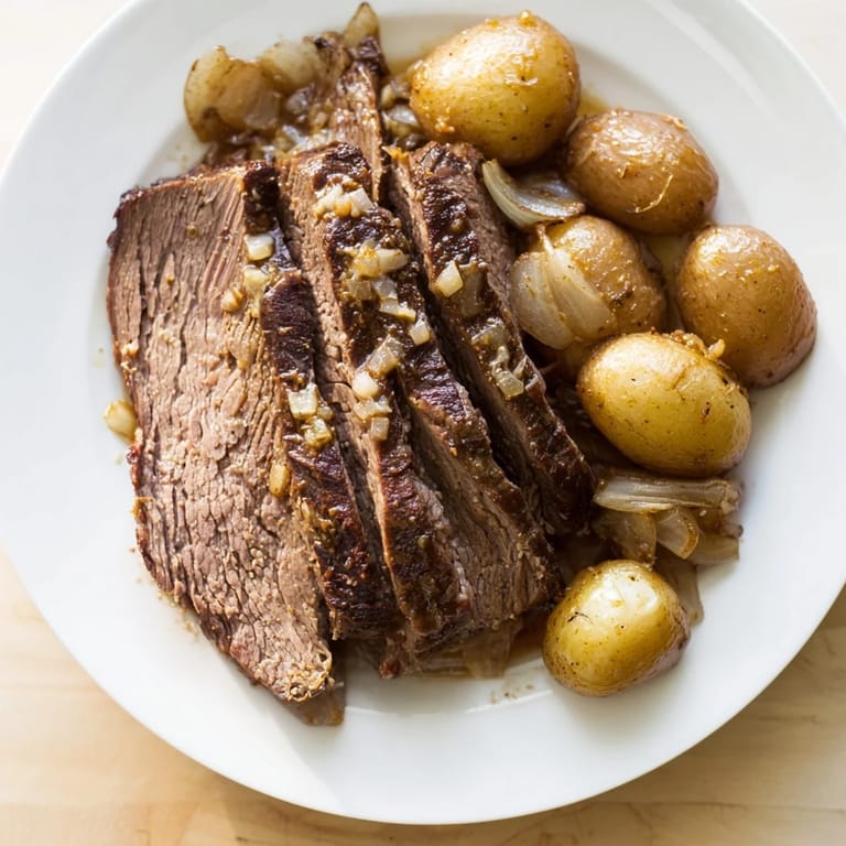 Steaming plate of slow cooker pot roast, featuring juicy beef, tender potatoes, and a delicious sauce.