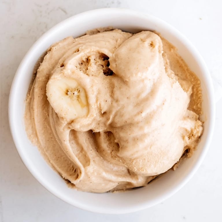 This vibrant photo shows a bowl of homemade 2-Ingredient Banana Ice Cream, perfectly smooth and sweet.