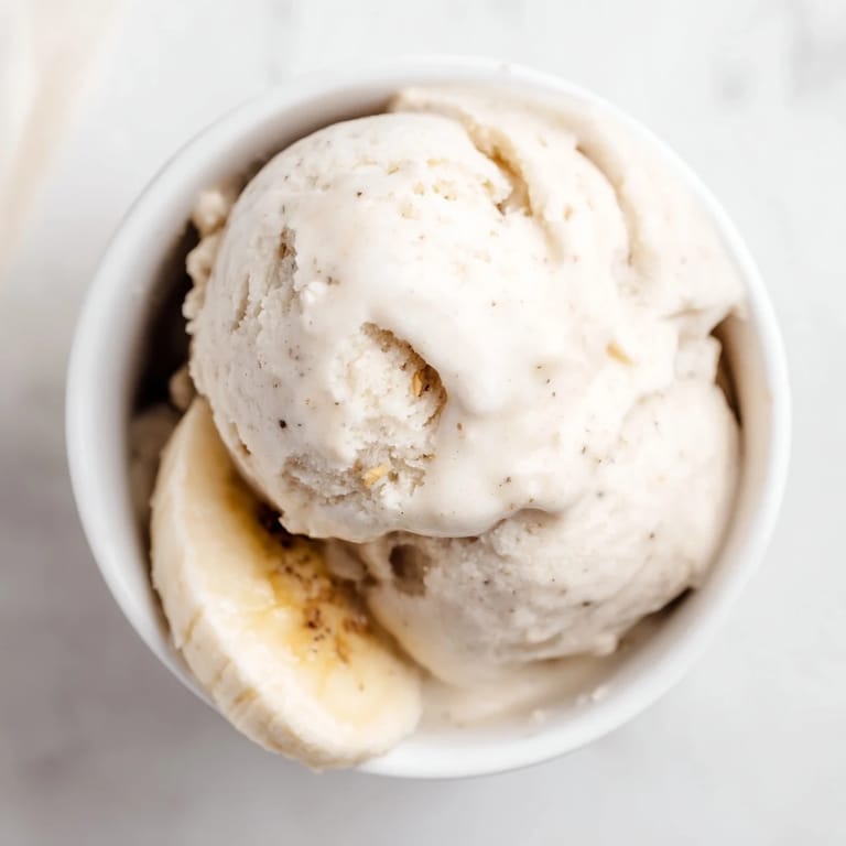 Frozen banana slices transformed into delicious 2-Ingredient Banana Ice Cream, ready for a scoop.