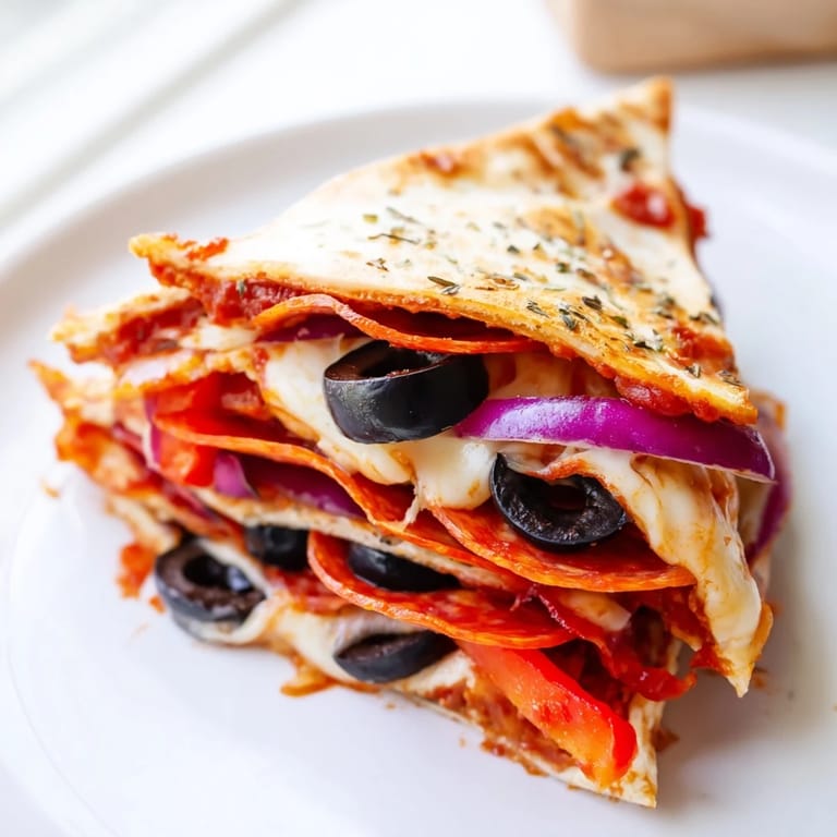 A close-up of a golden brown Tortilla Pizza Wrap revealing melted mozzarella, pepperoni, and vibrant red bell peppers.