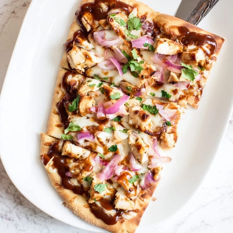Serving suggestion for BBQ Chicken Flatbread cut into wedges, showcasing crispy edges and bubbly cheese.