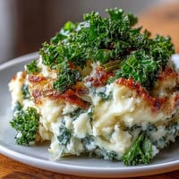 Creamy Irish-inspired colcannon mashed potatoes with sautéed leeks and crispy kale topping for a comforting vegetarian side dish.