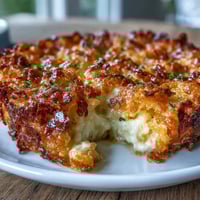 Funeral potatoes with crispy cornflake and cheddar crust, a cheesy casserole baked golden and bubbling for a comforting side dish.