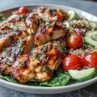 Grilled chicken breast with colorful vegetables and quinoa in a lemon vinaigrette dressing.